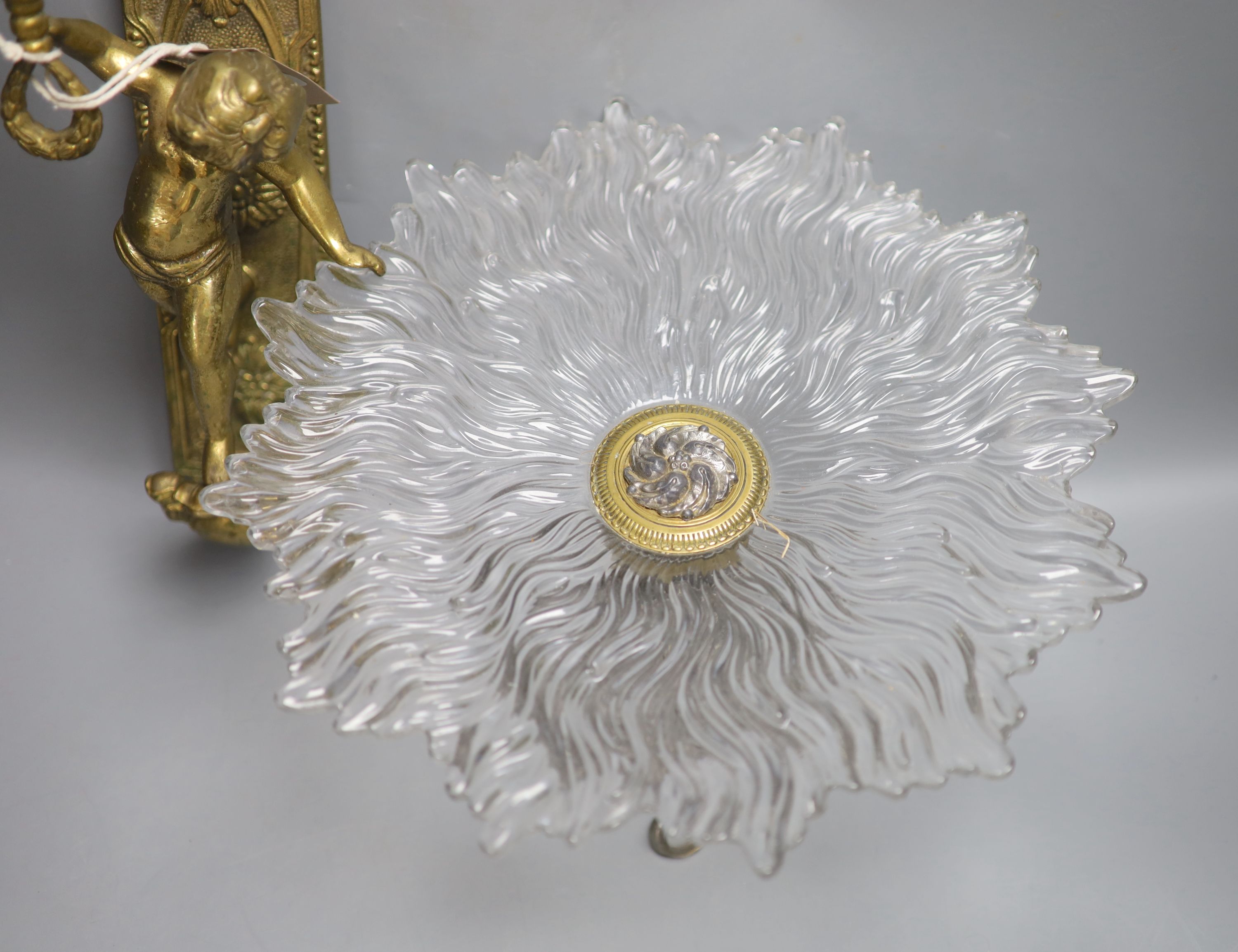 A moulded glass cake stand, on a cast metal base, diameter 31cm, and a cast brass wall sconce